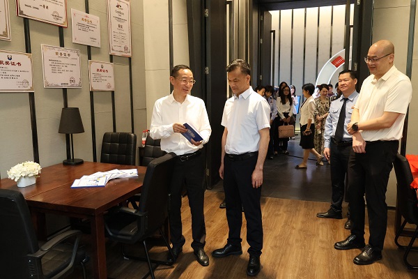 黄尚书（左二）、刘子林（左一）在税收普法教育研究室翻阅税法知识读本