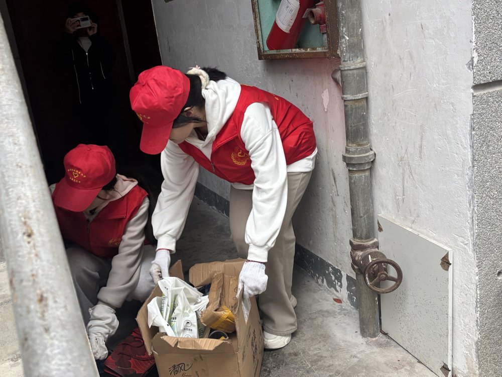 志愿者细心清理楼道杂物