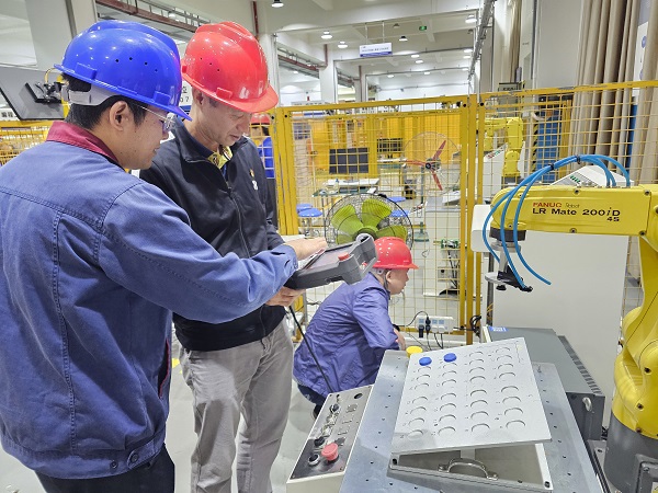 教师党员指导企业党员进行机器人操作